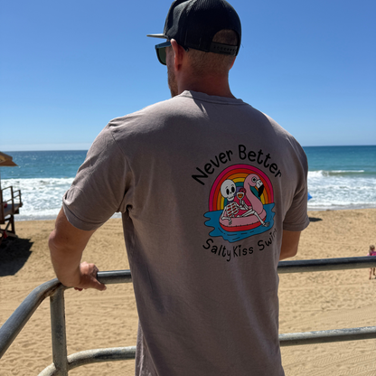 Man wearing a t-shirt with a graphic design of two cartoon characters on a beach.